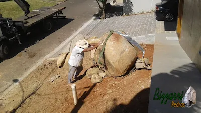 Bizzarri fazendo a execução do paisagismo com pedras com a máquina munck fazendo a colocação das pedras para fazer os canteiros sendo pedras ornamentais do tipo pedra moledo. 7 de março de 2017.