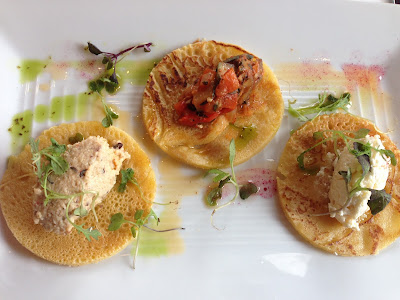 A trio of chickpea crepes were garnished with chili oil and topped separately with field pea hummus, heirloom squash ratatouille, and feta. 