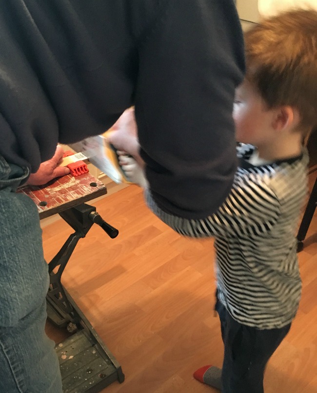 boy-helping-grandad-to-saw-wood