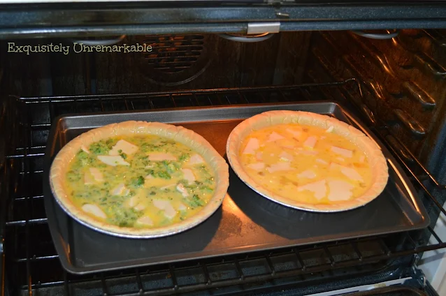 Raw cheese and broccoli quiches on a pan in the over