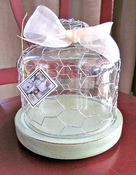 Glass cloche with bow and chicken wire on green dish