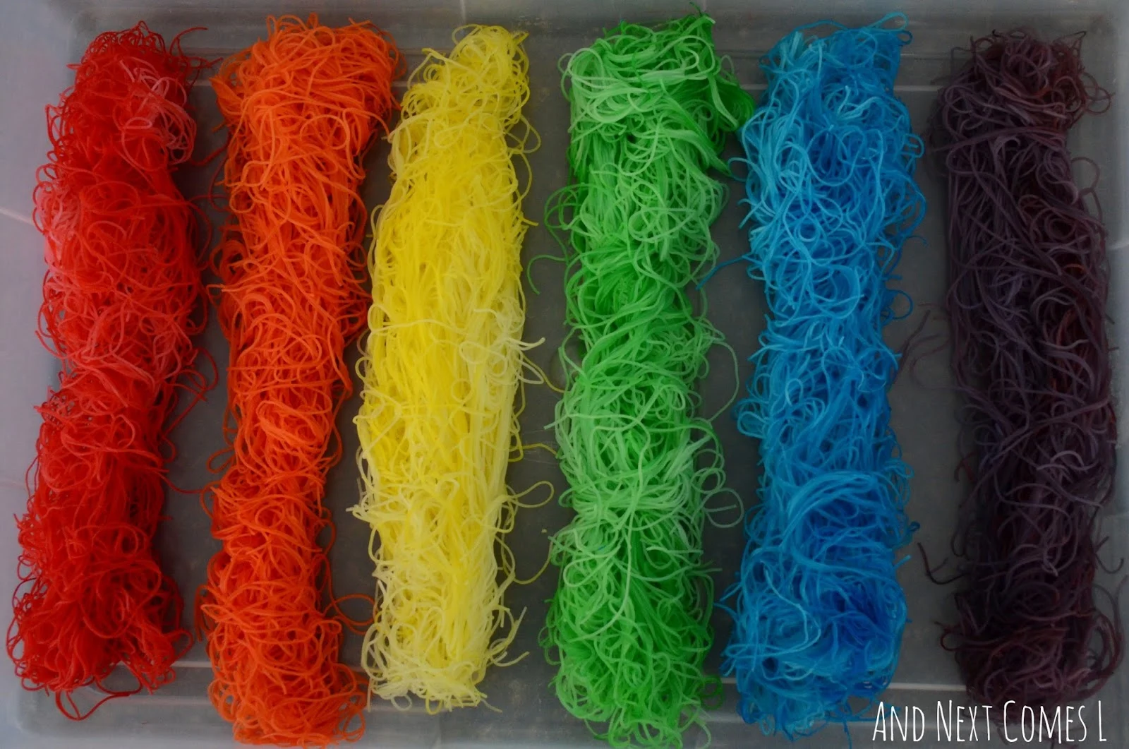 Rainbow rice noodles sensory bin for kids from And Next Comes L