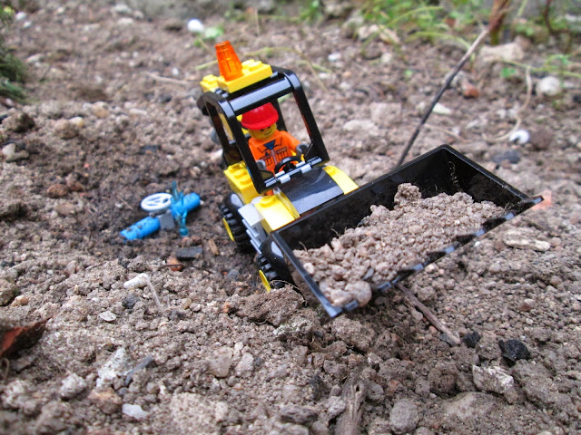 Diorama LEGO em cenário real, representando trabalhos de remoção de terras com máquina para substituição de conduta de água.com rutura. (10666 For Young Builders - Easy to build / Build & Rebuild)