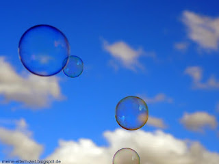 Seifenblasen vor Sommerhimmel mit Schönwetterwolken Kleinkindbespaßung mit Seifenblasen