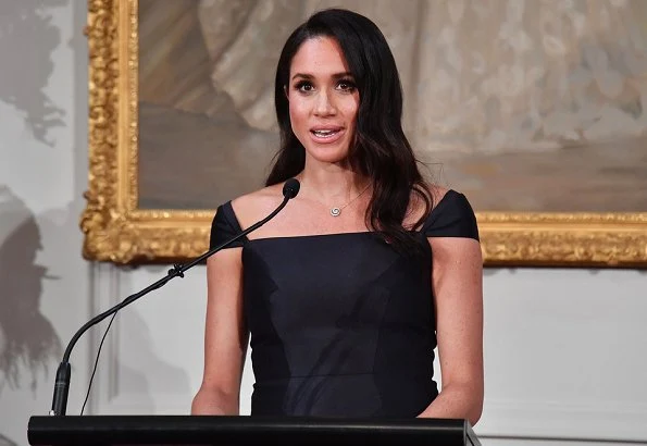 Meghan Markle wore a modified cap-sleeves navy dress by Gabriela Hearst and carried a navy leather clutch by Dior. Gabriela Hearst Navy Herve dress