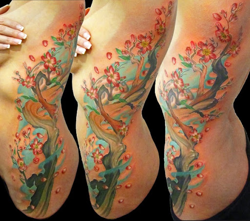 Multi colorido de flor de cerejeira da tatuagem no lado do corpo. Maravilhosamente colorido e um verdadeiro deleite para os olhos. Você pode definitivamente ver a beleza das flores de como eles se destacam pelo colorido ramos de uma árvore. (Foto: Fontes de imagem)