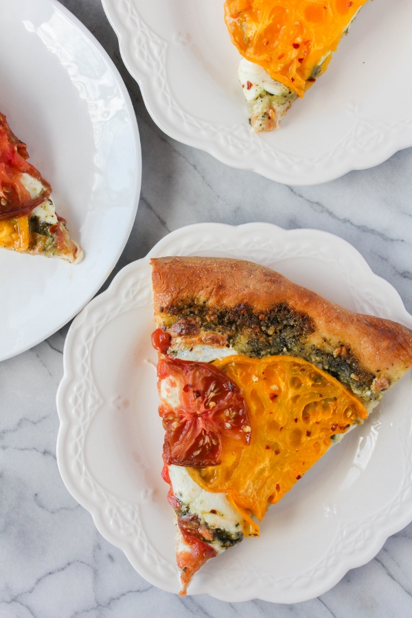 Fresh heirloom tomatoes and fresh mozzarella cheese are the stars of this beautiful Heirloom Tomato Pesto Pizza. It's a simple pizza, yet so delicious, and perfect for the summer!