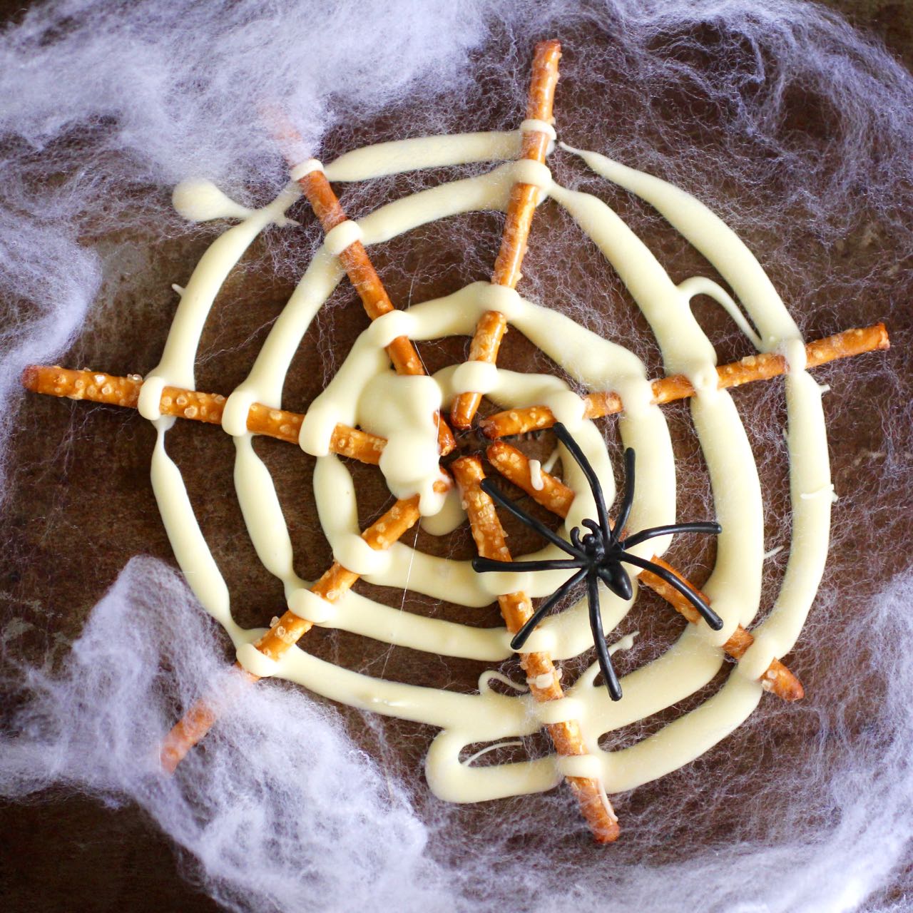 Green Gourmet Giraffe Halloween treat chocolate and pretzel spiderwebs