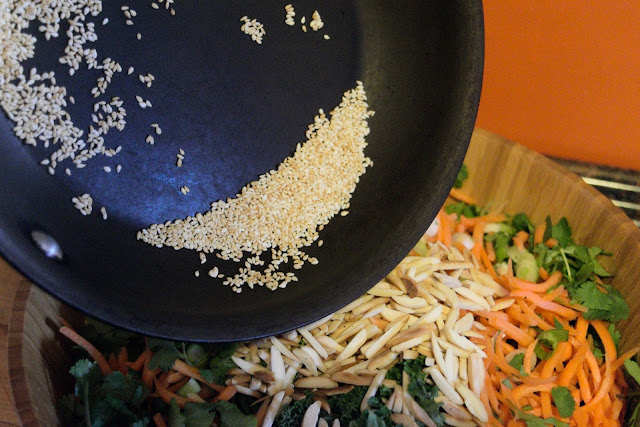 Sesame seeds being added to the salad.