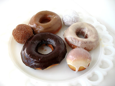 A photo of a plate of an assortment of homemade doughnuts.