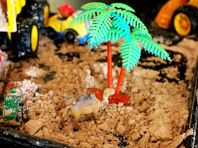 camel and palm tree in pretend dirt