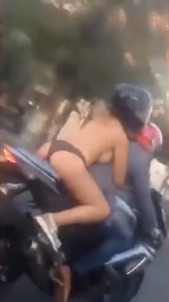 1 Woman is filmed riding on a bike dressed in just her panties and a pair of trainers