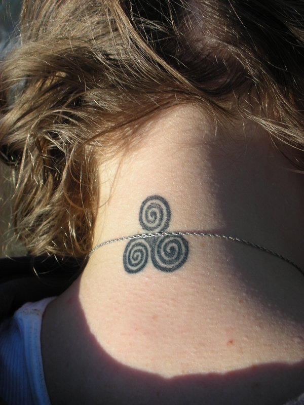 chica adolescente con el cabello recogido,lleva un tatuaje en la nuca de espirales celtas, 