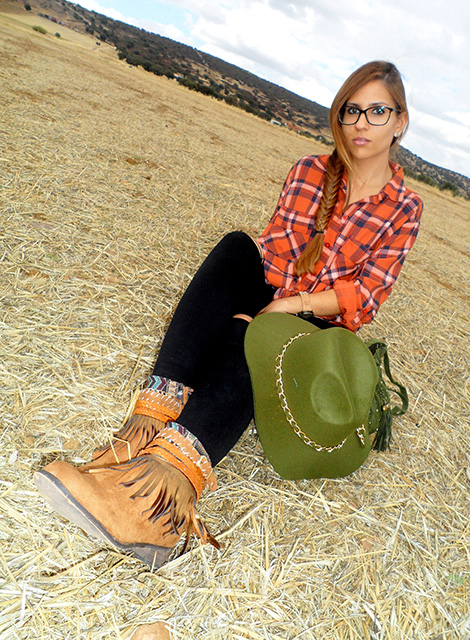 Camisa de cuadros con vaqueros rotos, botas boho, sombrero y bolso
