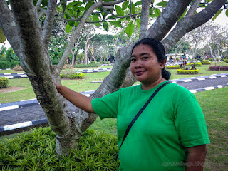 Sweet Woman Smile Enjoy A Holiday Shelter Between Plants And Tree In The Parking Lot At Badung, Bali, Indonesia
