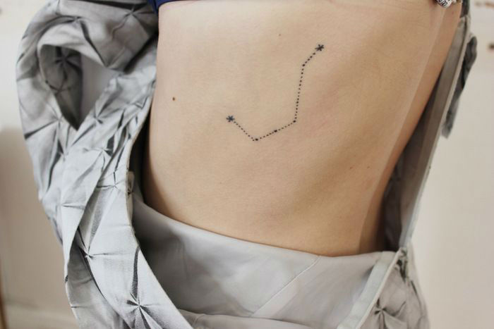 chica con tatuaje de constelacion en las costillas