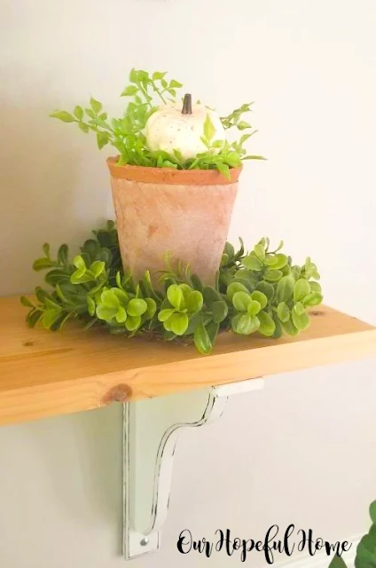 clay terra cotta pots green wreath white pumpkin dining room shelf