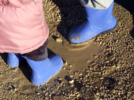 namc montessori sensorial work with soil exploring earth children's boots in mud puddle