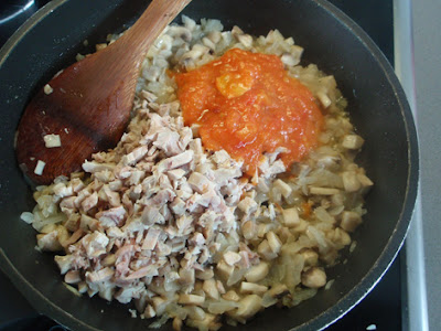 Elaboración de sofrito con cebolla, setas, conejo y tomate