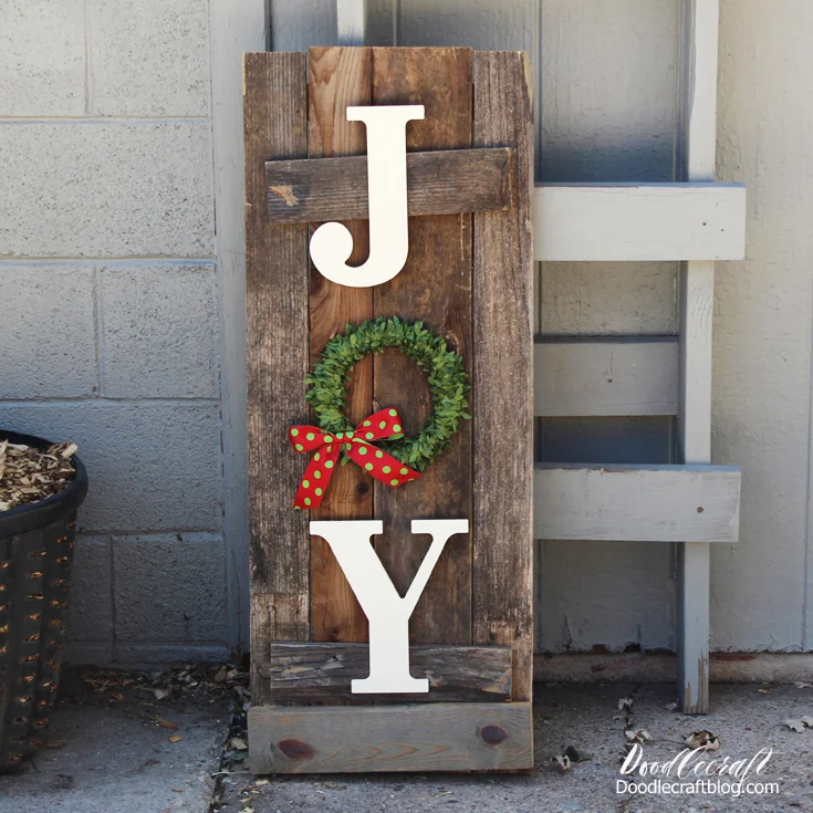 Make Christmas front porch decor with old reclaimed fence boards with the word JOY in a vertical design on the front, tall and skinny for standing near the front door.