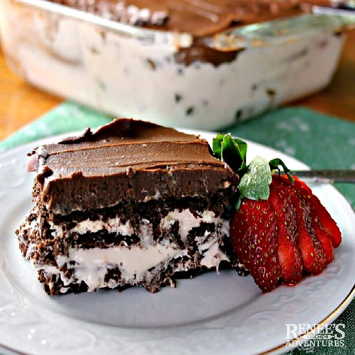 Chocolate-Strawberry Eclair Cake piece on plate with strawberry garnish