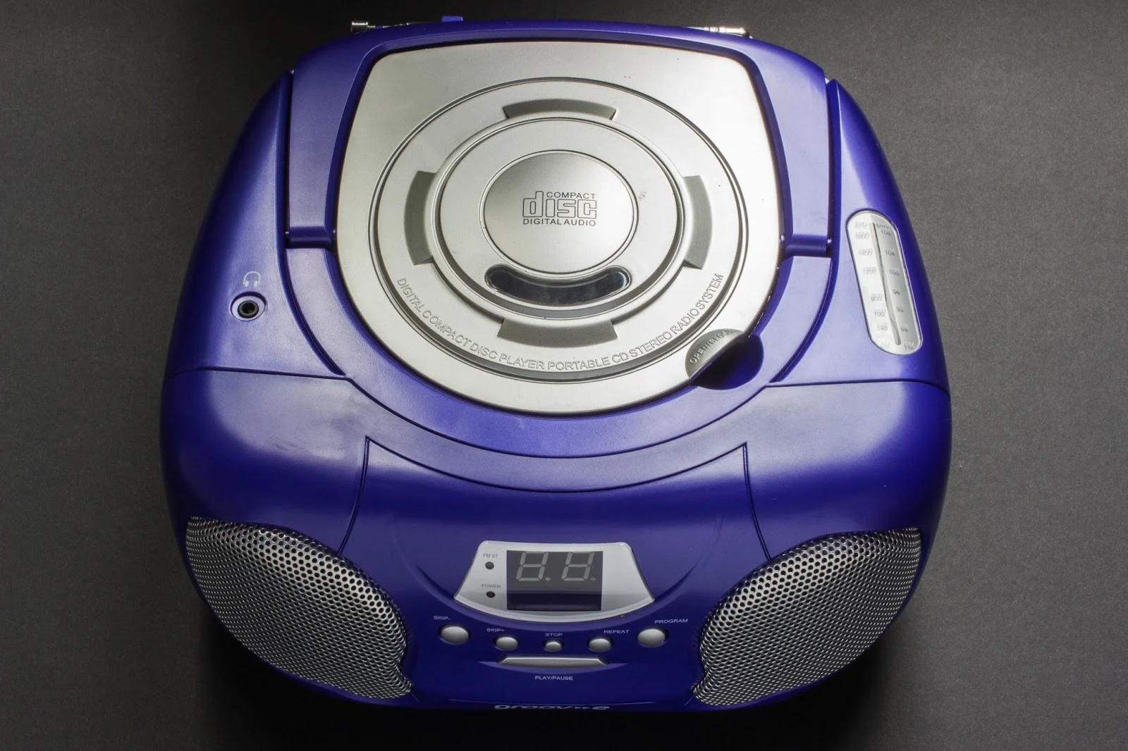 Purple stereo with 2 speakers and a cd player opening on top