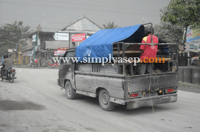 Mobil lewat di jalanan penuh debu yang dimuntahkan dari Gumung Merapi.  Anda harus menutup hidung anda dengan masker demi kesehatan.  Foto Dokumentasi Asep Haryono