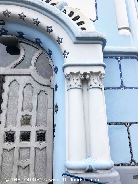 Blue and white painted art nouveau facade and entrance door decorated with stars, of a  catholic church.