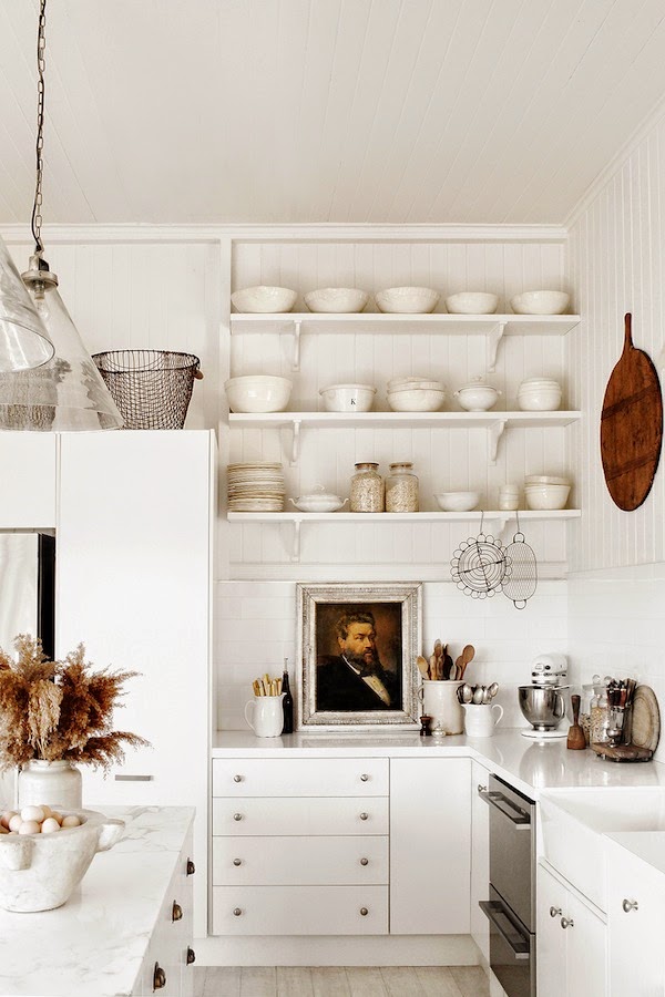 Black and White Interior Design Inspiration Kara Rosenlund white farmhouse country kitchen with oil painting portrait on counter and open shelving. #whitekitchen #moderncountry #vintagestyle