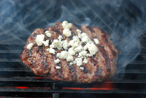 burger with blue cheese crumbles on grill