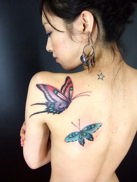 mujer asiatica de espaldas, vemos su tatuajes de mariposas en el omoplato y costado