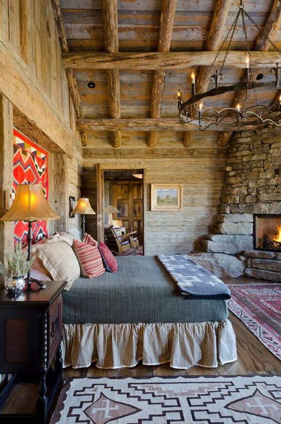 Cozy rustic log cabin bedroom with a stone fireplace