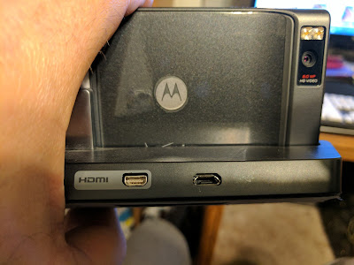 Motorola Droid X in a Charging Dock with Correct MicroUSB Port Orientation According to US Practices Motorola Droid X in a charging dock with microUSB port oriented correctly (broader edge down), according to practices in the USA.