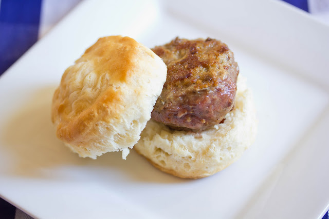 turkey sausage on a white plate with a biscuit