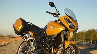 Oranje gouden motorfiets in de berm geparkeerd