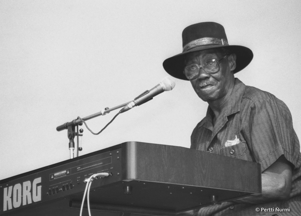 Why did Perkins give up guitar and start playing piano?