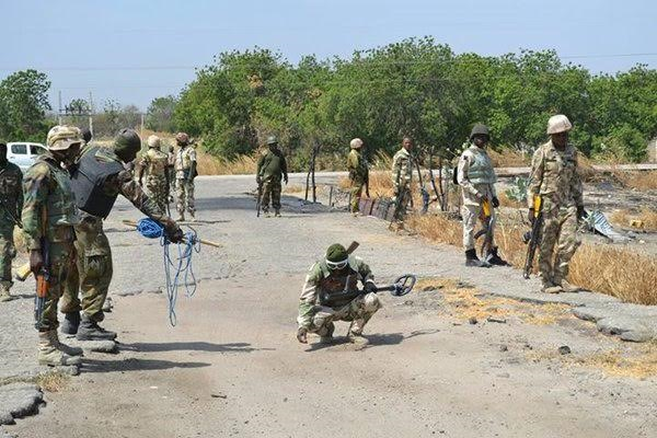 0000 Photo: A gallant Nigerian army combat pictured defusing landmines on a road in Borno