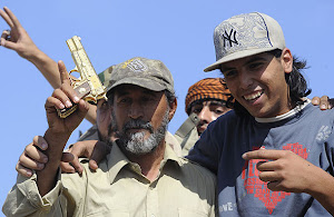 A man holds up what is thought to be Gaddafi's golden gun