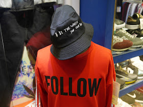 "Be The Worst You Can Be" hat with "Follow" shirt on a mannequin at a shop in Jiangmen
