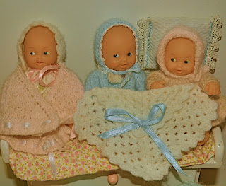 NIñas juegan con sus muñecos envueltos con las mantas de abuela hechas a ganchillo