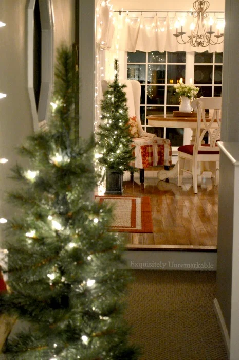 Country Christmas Kitchen Decor with two small lit trees one next to a round kitchen table