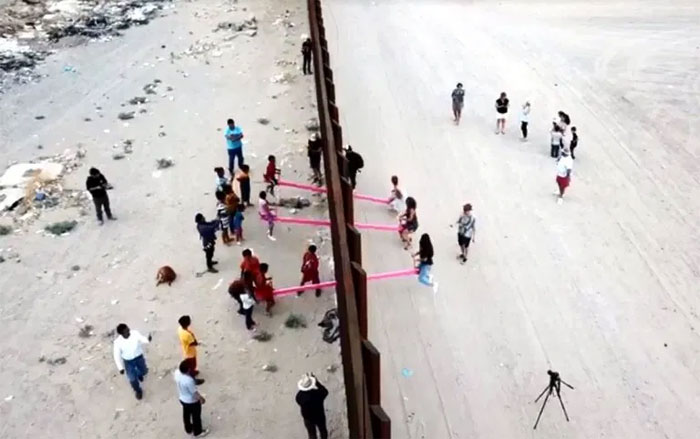 US And Mexico Kids Play Together On Seesaws Built On The Border Wall In Defiance Of Donald Trump