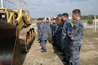 Bir iş makinesi yanında eğitim alan istihkam birliği askerleri