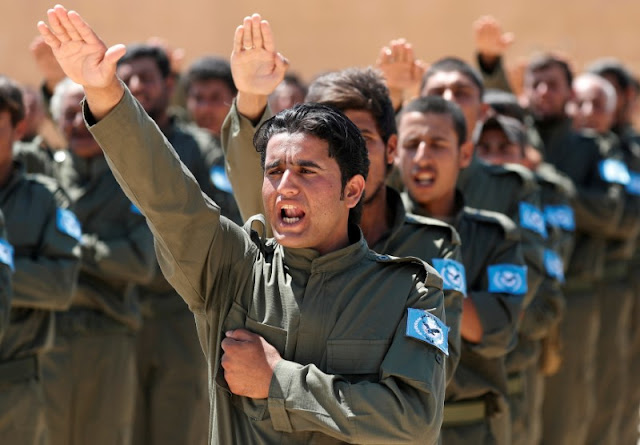 FILE PHOTO: Graduates of a U.S.-trained police force, which expects to be deployed in Raqqa, salute during a graduation ceremony near Ain Issa village, north of Raqqa, Syria, June 17, 2017. REUTERS/Goran Tomasevic/File Photo