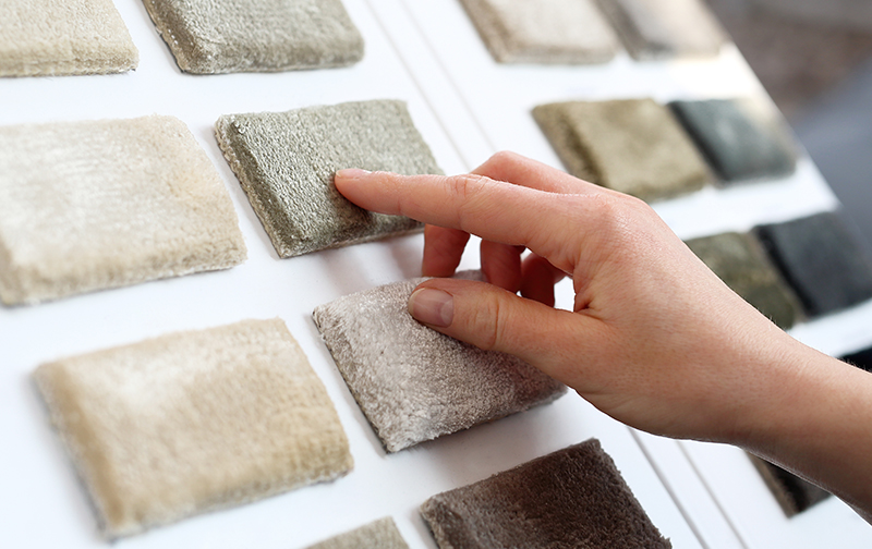 woman selecting new carpet from samples