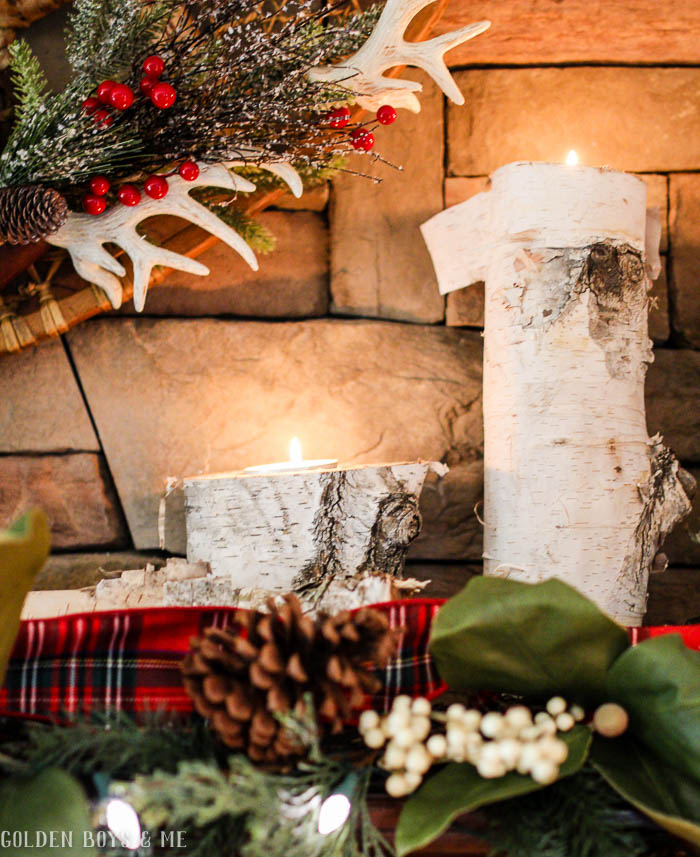 Holiday mantel with birch logs used as candle holders with plaid scarf