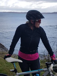 woman with road biking standing with sea and island background