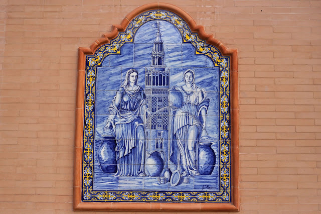 Azulejos pintados con motivos religiosos sobre una pared de ladrillo.