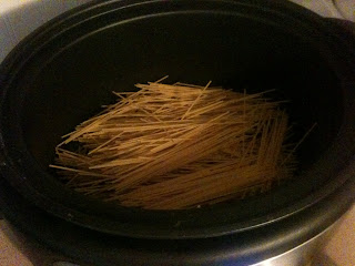 Spaghetti noodles placed inside of a crockpot.
