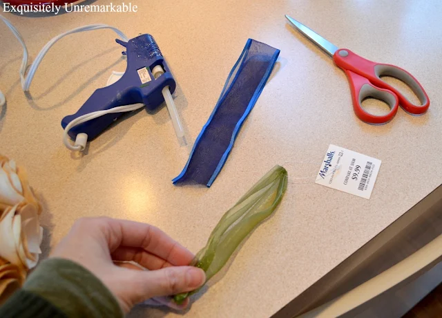 Green and blue ribbon on counter with scissors